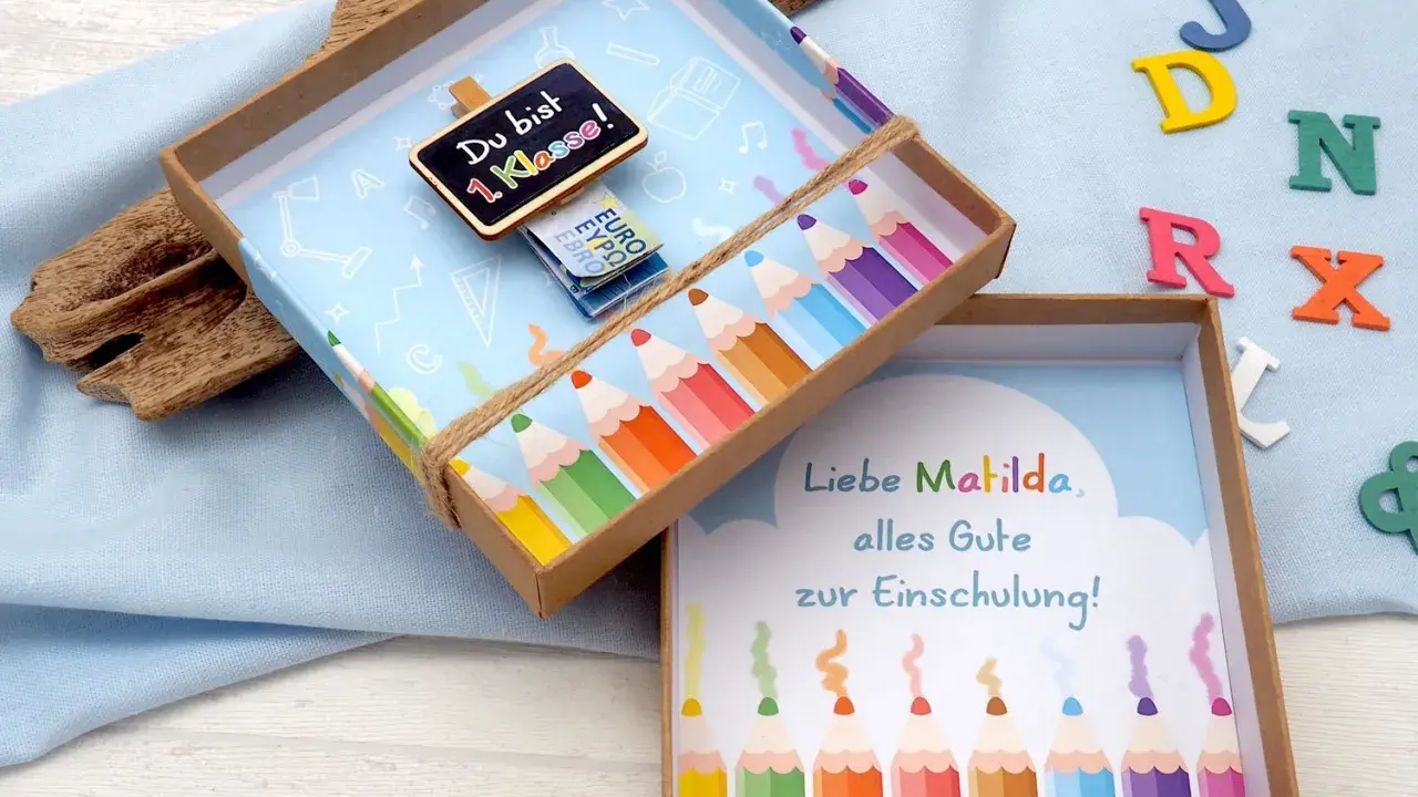 Kreatives Geldgeschenk zur Einschulung basteln: Eine Schultüte mit Bleistiften und einer Tafel "Du bist 1. Klasse!".