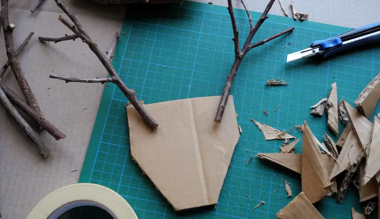 Bastelideen: Pappmache selber machen mit Zweigen und Karton. Ein Basteltisch mit Werkzeug und Materialien für kreative Projekte.