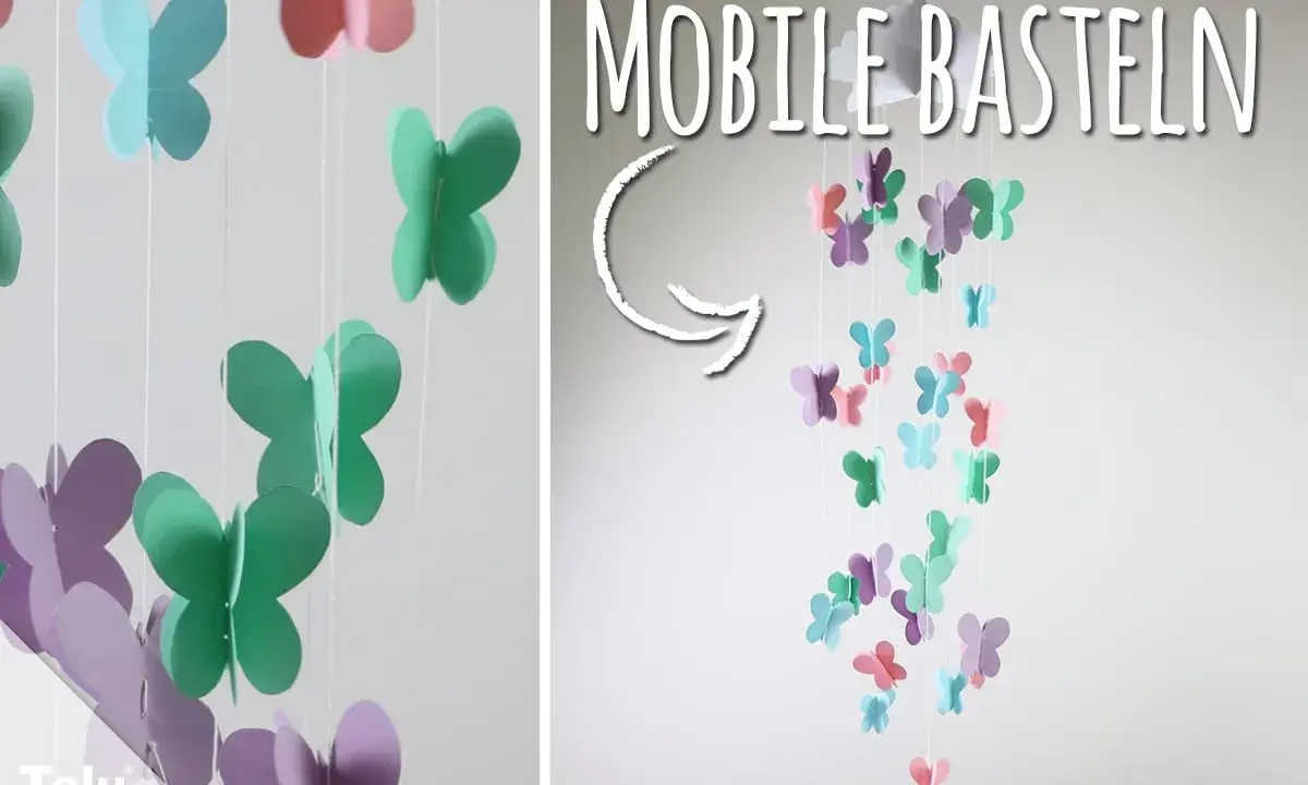 Bunte Schmetterlinge aus Papier hängen an Schnüren und bilden ein Mobile. Hier gibt es kostenlose mobile basteln vorlagen!