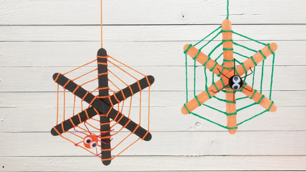 Zwei selbstgebastelte Spinnennetze aus Eisstielen und Wolle, mit kleinen Spinnen und Kulleraugen. Perfekt zum Spinnennetz basteln für Halloween!