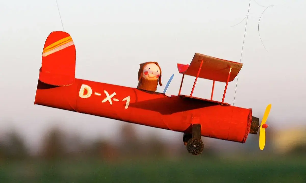 Rotes Bastel-Flugzeug mit Puppen-Pilot, D-X-1, fliegt. Eine tolle Vorlage zum Nachbasteln!