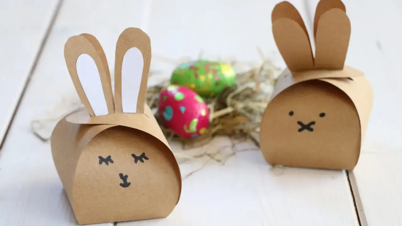 Zwei niedliche Osterhasen-Schachteln aus Pappe, inspiriert von einer Vorlage, mit bunten Ostereiern im Nest.