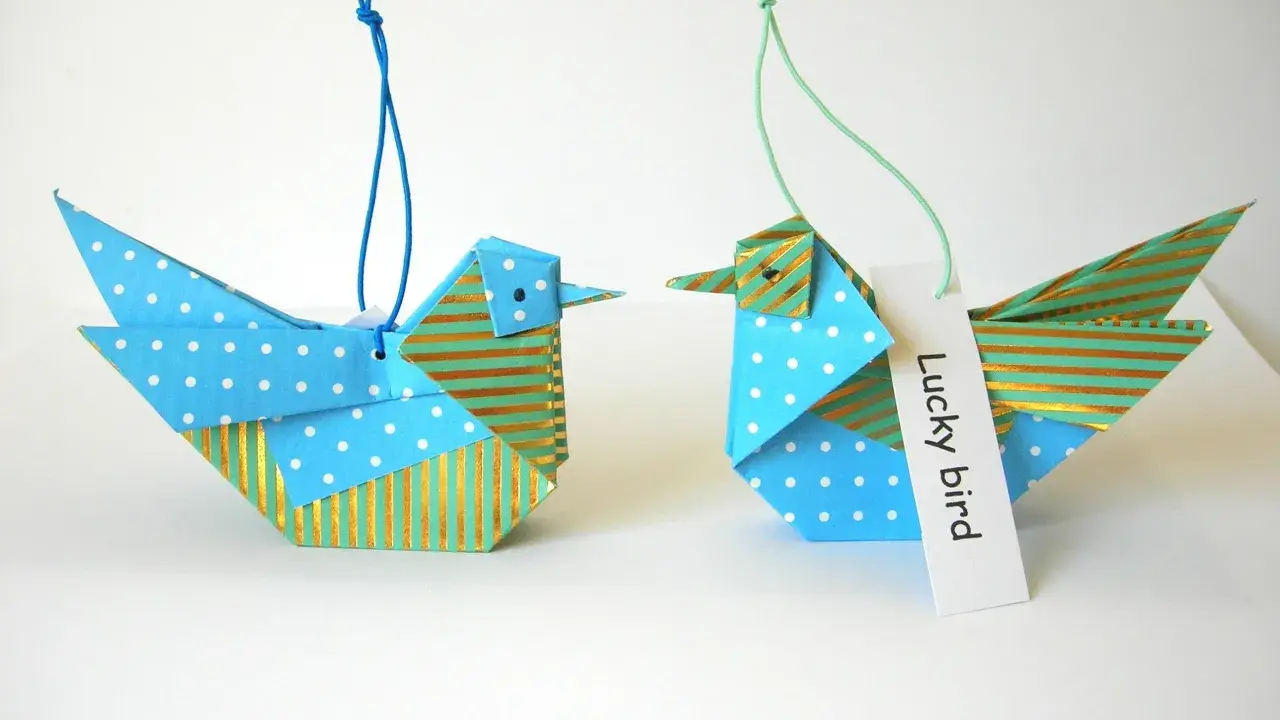Zwei Origami-Vögel, die zum **Vogel Mobile basteln** einladen. Einer mit Punkten, der andere mit Streifen.