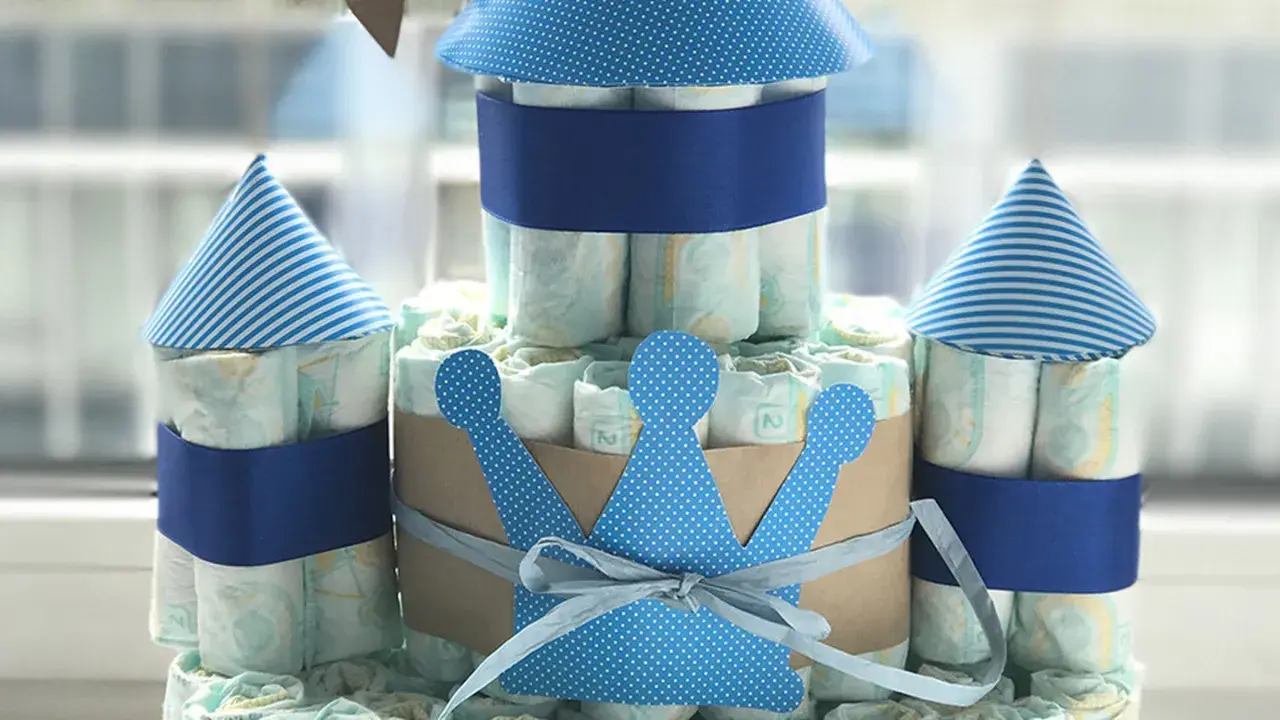 Eine Windeltorte als Schloss, mit blauen Türmen und einer Krone. So kann man eine Windeltorte selber machen!