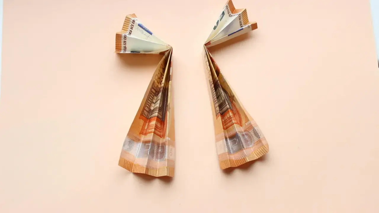 Zwei gefaltete 50-Euro-Scheine bilden Flügel, die an Geldengel falten anleitungen erinnern.