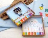 Kreatives Geldgeschenk zur Einschulung basteln: Eine Schultüte mit Bleistiften und einer Tafel "Du bist 1. Klasse!".
