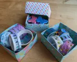 Bunte schachtel falten mit deckel, gefüllt mit Washi-Tapes und Glitzer-Schmetterlingen.