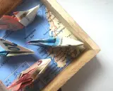 Kreative **Geldscheine falten** zu Schiffen, die auf einer Karte der norwegischen See segeln. Eine **muschel**-förmige Faltung ist nicht zu sehen, aber die Origami-Boote sind detailreich.