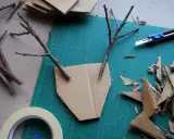 Bastelideen: Pappmache selber machen mit Zweigen und Karton. Ein Basteltisch mit Werkzeug und Materialien für kreative Projekte.