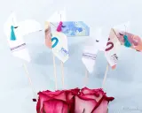 Origami-Pferde aus Geld gefaltet, mit bunten Quasten und Rosen. Ein kreatives Geldgeschenk.