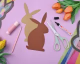 Bastelmaterialien für einen Osterhasen aus Tonpapier: Schere, Stift, Kleber, Tulpen und Hasen-Vorlagen.