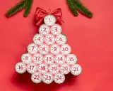 Kreativer Adventskalender aus Klorollen, geformt wie ein Weihnachtsbaum, mit nummerierten Türchen von 1 bis 24.