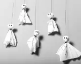 Fünf schwebende Geister aus weißem Papier, perfekt für Halloween Deko selber machen Vorlagen. Einfach und gruselig!