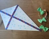 Ein selbstgebastelter Drachen mit Schneeflockenmuster und bunten Bändern, ideal als bastelvorlagen kinder.