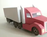 Ein roter LKW mit weißem Auflieger, liebevoll aus Papier gebastelt.