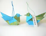 Zwei Origami-Vögel, die zum **Vogel Mobile basteln** einladen. Einer mit Punkten, der andere mit Streifen.