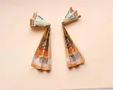Zwei gefaltete 50-Euro-Scheine bilden Flügel, die an Geldengel falten anleitungen erinnern.