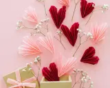 Verliebte selbstgemachte Valentinstag Geschenke selber machen: Papierherzen in Rot & Rosa, Gänseblümchen und eine Geschenkbox.
