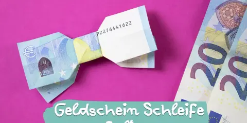 Eine Fliege aus Geld falten ist eine kreative Idee für Geschenke. Hier siehst du eine gefaltete Geld-Fliege auf pinkem Hintergrund.
