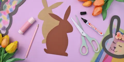 Bastelmaterialien für einen Osterhasen aus Tonpapier: Schere, Stift, Kleber, Tulpen und Hasen-Vorlagen.