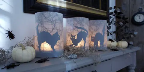 Gruselige Halloween-Windlichter mit Katzen-Silhouetten, Spinnweben und kleinen Kürbissen. Perfekt zum Windlicht Halloween basteln!