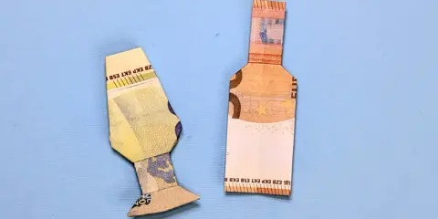 Zwei gefaltete Euroscheine, die eine Flasche und eine Art Vase darstellen. Geld falten flasche.