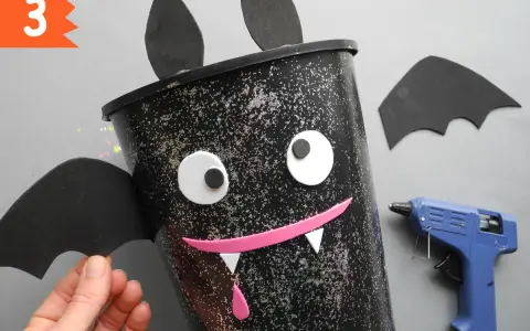 Schritt 3: Ein Fledermaus-Eimer für Halloween basteln. Mit Heißkleber und Bastelmaterialien entsteht ein gruseliger Hingucker.