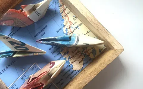 Kreative **Geldscheine falten** zu Schiffen, die auf einer Karte der norwegischen See segeln. Eine **muschel**-förmige Faltung ist nicht zu sehen, aber die Origami-Boote sind detailreich.