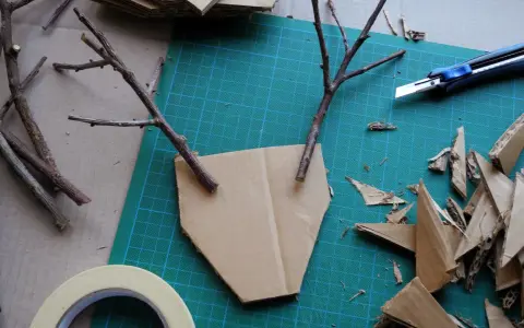 Bastelideen: Pappmache selber machen mit Zweigen und Karton. Ein Basteltisch mit Werkzeug und Materialien für kreative Projekte.