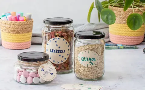 DIY Etiketten zum Ausdrucken verschönern Gläser mit Leckerlis, Quinoa und Snacks. Liebevoll gestaltet für die Küche.