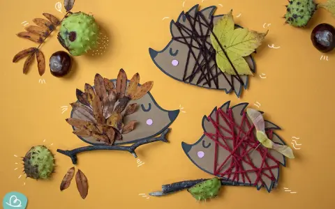 Drei Igel-Bastelvorlagen aus Papier mit Blättern, Garn und Ästen. Ein Igel hat braunes Garn, ein anderer Herbstblätter, der dritte ist mit roten Garn verziert.