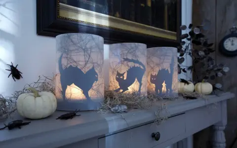 Gruselige Halloween-Windlichter mit Katzen-Silhouetten, Spinnweben und kleinen Kürbissen. Perfekt zum Windlicht Halloween basteln!