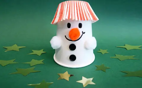 Ein süßer Schneemann basteln mit Becher, Wattebällchen und Sternenkonfetti.