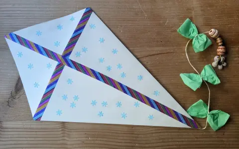 Ein selbstgebastelter Drachen mit Schneeflockenmuster und bunten Bändern, ideal als bastelvorlagen kinder.