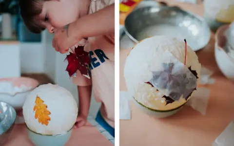 Kind bastelt eine Laterne: Luftballon, Kleister und Herbstblätter werden zu einem Kunstwerk.