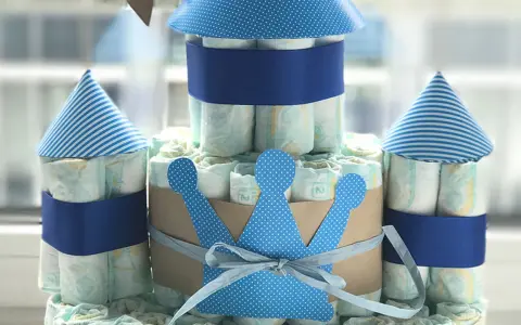 Eine Windeltorte als Schloss, mit blauen Türmen und einer Krone. So kann man eine Windeltorte selber machen!