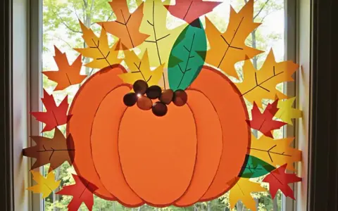 Herbstliche Fensterdeko basteln mit Kindern: Vorlagen für bunte Blätter und einen großen Kürbis schmücken das Fenster.