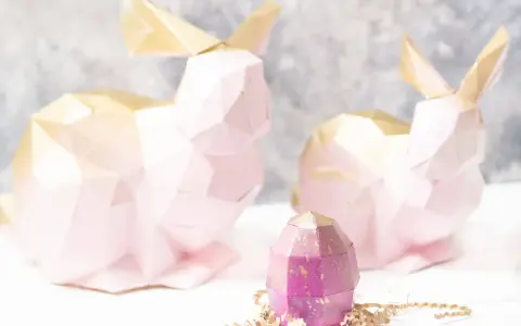 Zwei rosa 3D Origami Hasen mit goldenen Ohren und ein lila Ei. Eine Anleitung für 3d origami hase anleitung wäre hier toll.