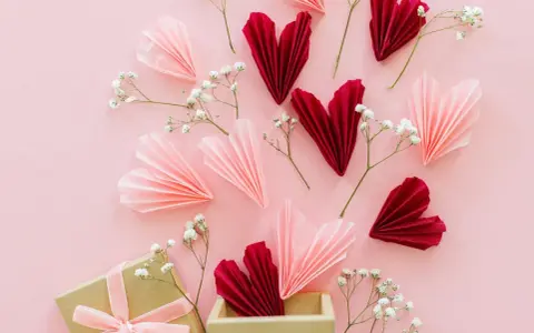 Verliebte selbstgemachte Valentinstag Geschenke selber machen: Papierherzen in Rot & Rosa, Gänseblümchen und eine Geschenkbox.