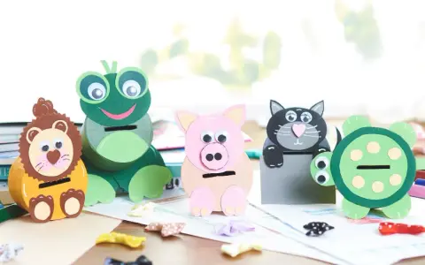 Vier selbstgebastelte Spardosen in Tierform: Löwe, Frosch, Schwein und Katze. Eine Schildkröte steht daneben.