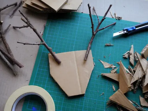 Bastelideen: Pappmache selber machen mit Zweigen und Karton. Ein Basteltisch mit Werkzeug und Materialien für kreative Projekte.