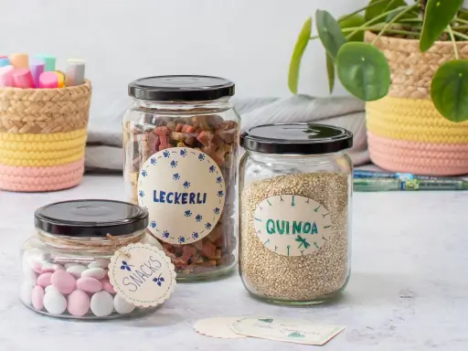 DIY Etiketten zum Ausdrucken verschönern Gläser mit Leckerlis, Quinoa und Snacks. Liebevoll gestaltet für die Küche.