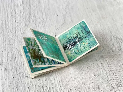 Ein aufgeschlagenes Leporello zum Thema "Soul" mit abstrakten, grünen und blauen Mustern, ideal zum Basteln.