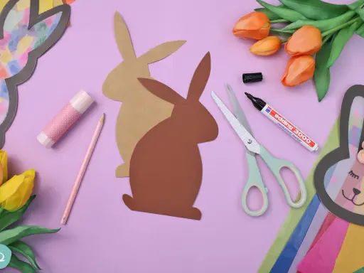 Bastelmaterialien für einen Osterhasen aus Tonpapier: Schere, Stift, Kleber, Tulpen und Hasen-Vorlagen.