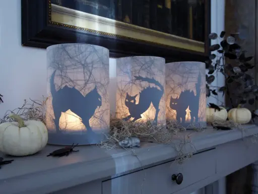 Gruselige Halloween-Windlichter mit Katzen-Silhouetten, Spinnweben und kleinen Kürbissen. Perfekt zum Windlicht Halloween basteln!