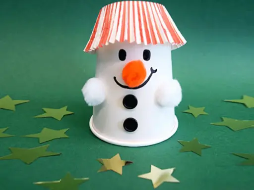 Ein süßer Schneemann basteln mit Becher, Wattebällchen und Sternenkonfetti.