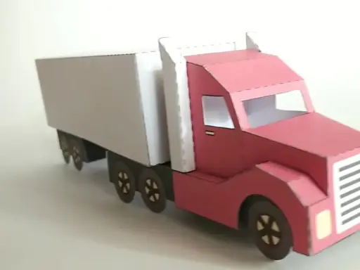 Ein roter LKW mit weißem Auflieger, liebevoll aus Papier gebastelt.