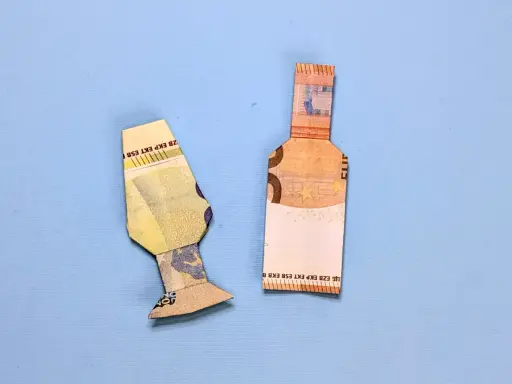 Zwei gefaltete Euroscheine, die eine Flasche und eine Art Vase darstellen. Geld falten flasche.
