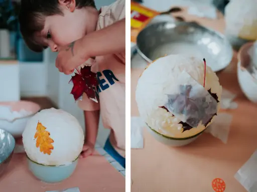 Kind bastelt eine Laterne: Luftballon, Kleister und Herbstblätter werden zu einem Kunstwerk.