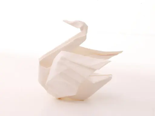 Ein weißer Origami-Schwan, der Eleganz und Reinheit symbolisiert. Die Bedeutung des Origami-Schwan steht für Glück und Treue.